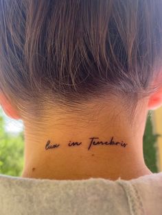 the back of a woman's neck has a tattoo that reads live in tomorrow