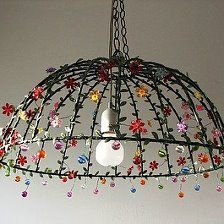 a chandelier hanging from the ceiling with colorful beads and flowers attached to it