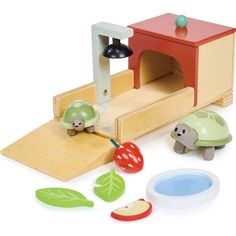 a wooden toy set with turtle and tortoise on the ground next to it