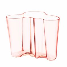 a pink glass vase sitting on top of a white table