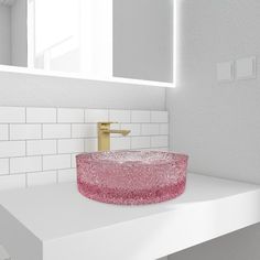 a bathroom sink with a pink glass bowl