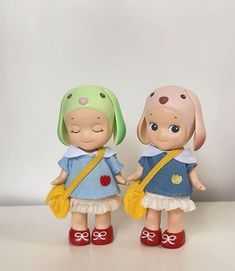 two little dolls standing next to each other