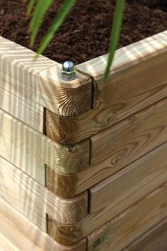 a wooden planter filled with dirt and grass