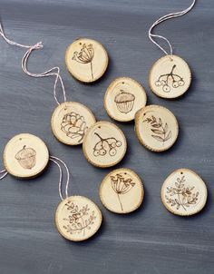 wood burned ornaments are hanging from strings on a chalkboard background with string attached to each ornament