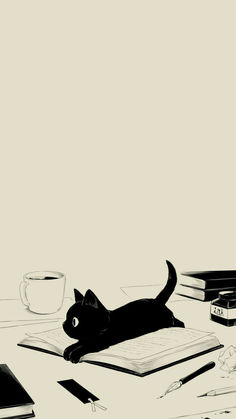 a black cat laying on top of an open book next to a cup and pen