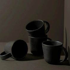 three black cups sitting next to each other