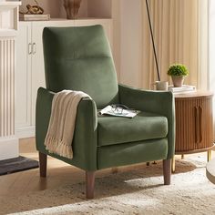 a green chair with a blanket on it in a living room