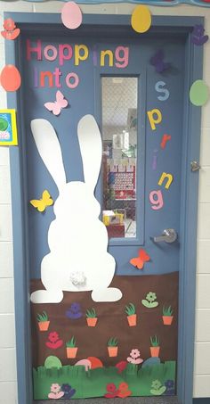 a door decorated to look like a bunny with the words hopping into spring on it