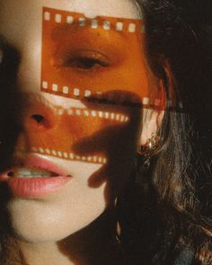 a woman's face is reflected in a film strip with the image projected on it