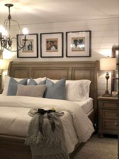 a large bed sitting in a bedroom next to two lamps and pictures on the wall