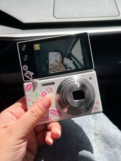 a person holding up a camera to take a picture in the car with their cell phone