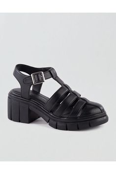 Vegan synthetic upper/Adjustable buckle closure/Fisherman-style silhouette/Round toe/Elevated platform heel/Not eligible for promotions | Only ships within the USA Womens Fisherman Sandals, Black T-strap Sandals With Padded Heel, Black Synthetic T-strap Sandals With Buckle Closure, Synthetic T-strap Sandals With Buckle Closure, Trendy T-strap Sandals With Buckle Closure, Platform T-strap Synthetic Sandals, Spring Platform T-strap Sandals, Synthetic T-strap Heels With Buckle Closure, Fisherman Style