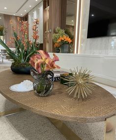 a coffee table with flowers and other decorations on it in a living room or dining room