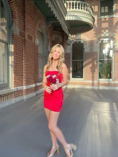 a woman in a red dress is posing for the camera with her hand on her hip