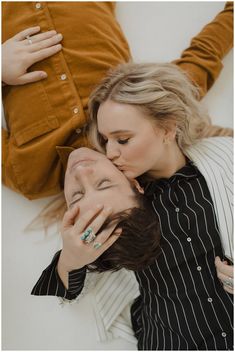 two people laying on the ground with their heads close to each other and one person touching his face