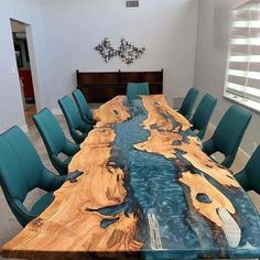 a large table with blue chairs around it and a wooden slab that has been made to look like a river