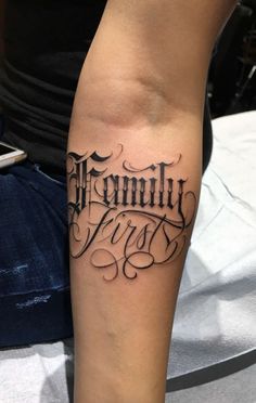 a woman's arm with the word family first tattooed on it, in black ink