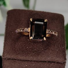 an engagement ring with a green tourmaline surrounded by diamonds