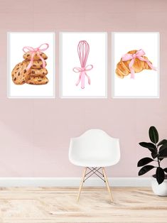 three paintings of cookies with pink bows on the wall next to a chair and potted plant