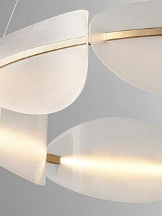 three circular lights hanging from the ceiling in a white room with gold trimmings