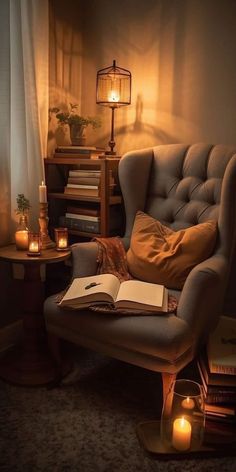 an open book sitting on top of a chair next to a table with candles and books