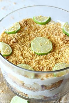 a layered dessert with limes and graham crackers in a glass dish on a table