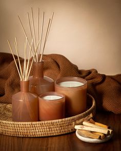 candles and cinnamon sticks sit on a tray