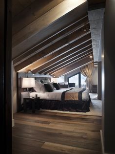 an attic bedroom with wood floors and white bedding