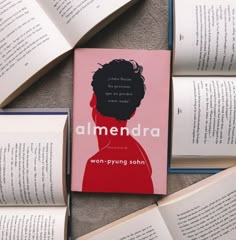 an open book sitting on top of a table next to several books with the words amendra written on them