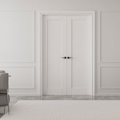 an empty white room with two chairs and a rug on the floor in front of it