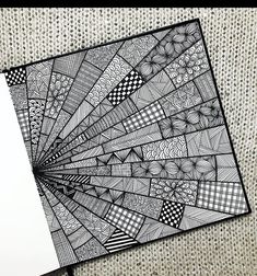 a black and white drawing on top of a piece of paper next to a pen