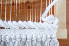 a close up of a weaving machine with white yarn