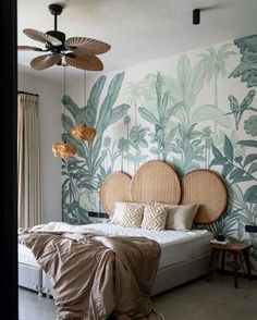 a bedroom with a bed, ceiling fan and wallpaper in the shape of palm leaves