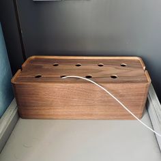 a wooden box sitting on top of a floor next to a light switch and wall