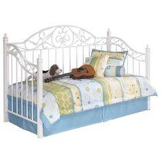 a white metal day bed with a guitar on it's pillow and coverlet