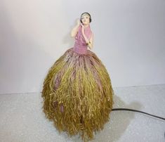 a figurine sitting on top of a grass ball