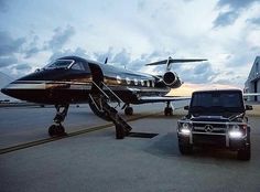 a black truck parked next to an airplane