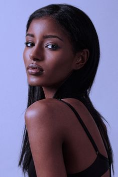 a woman with long black hair is posing for the camera