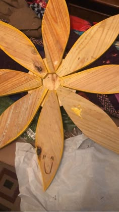 a wooden flower is sitting on top of some fabric