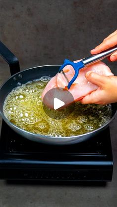 someone is using scissors to cut meat into pieces in a frying pan on the stove