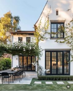 a white house with lots of windows and plants