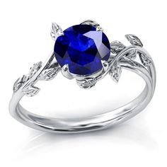 a blue sapphire ring with leaves on the sides and an oval stone in the center