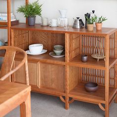 a wooden shelf filled with dishes and cups