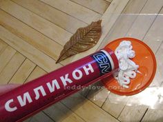 a tube of toothpaste sitting on top of a wooden floor next to a leaf