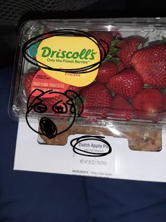 a plastic container filled with lots of strawberries