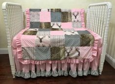 a crib bed with a pink and gray quilt on it's coverlet