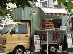 a small food truck parked on the side of the road in front of a building