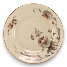 a white plate with pink flowers and gold trim on the rim, against a white background