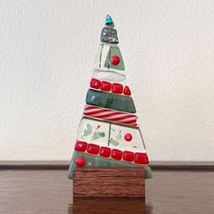 a glass christmas tree sitting on top of a wooden table