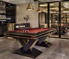 a pool table in the middle of a room with two lamps hanging from it's ceiling